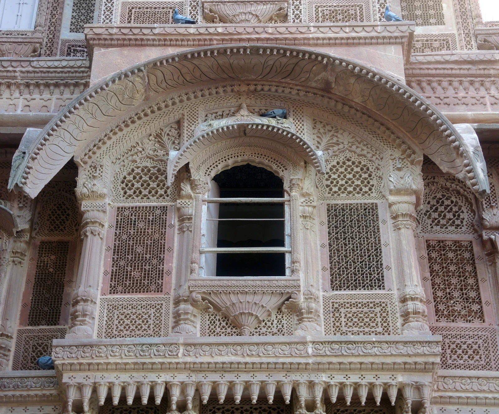 Intricately carved sandstone jharokha window on Mehrangarh’s palace facade.