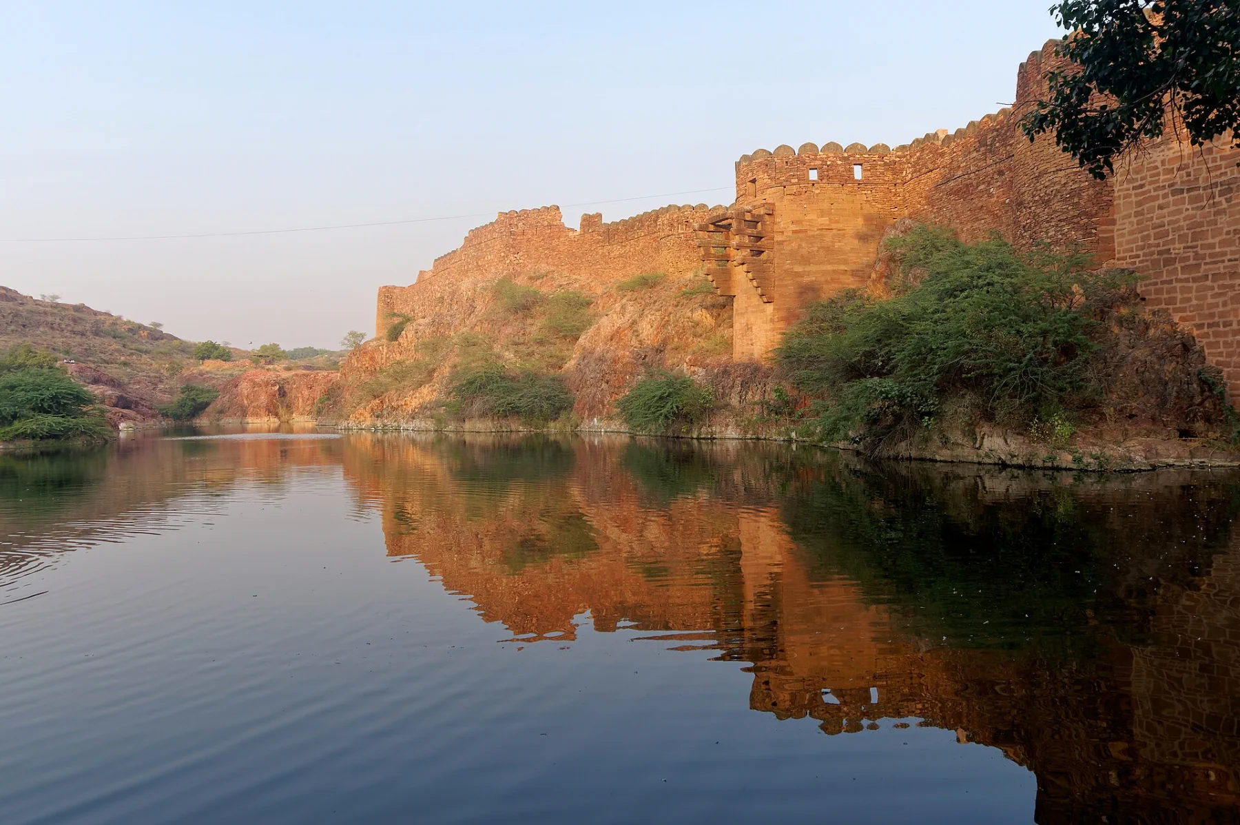 Mehrangarh’s sandstone wall reflected in the still water of Ranisar Lake.